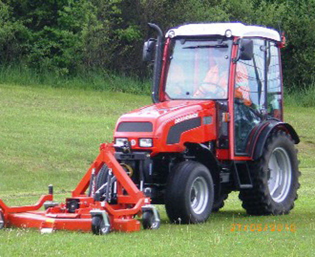 Traktor mit Frontmulcher bei Arbeitseinsatz auf Wiese