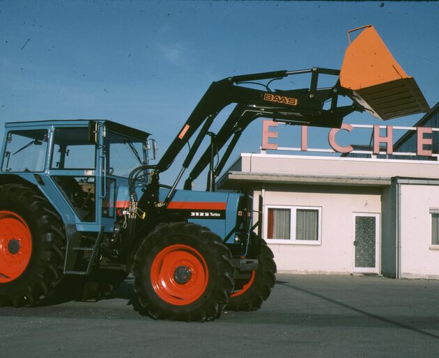 Moderner EICHER Traktor mit Frontlader vor Gebäude
