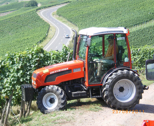 Traktor fährt an Hanglage mit montiertem Mulchgerät